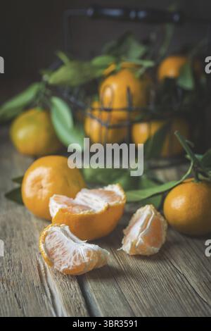 Mandarinen mit grünen Blättern. Tangerinen close-up auf einem hölzernen Hintergrund. Hintergrund Tangerinen Stockfoto