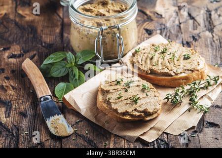 Frische hausgemachte Huhn Leber Pastete auf Brot über rustikale Hintergrund Stockfoto