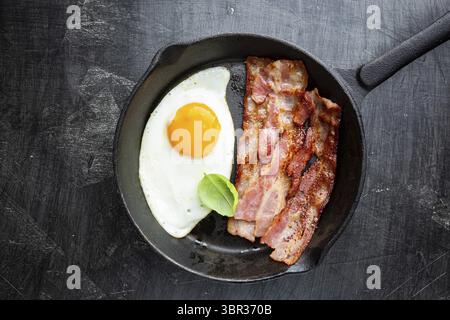 Spiegeleier und Speck zum Frühstück auf einer Pfanne, Ansicht von oben, Copyspace Stockfoto