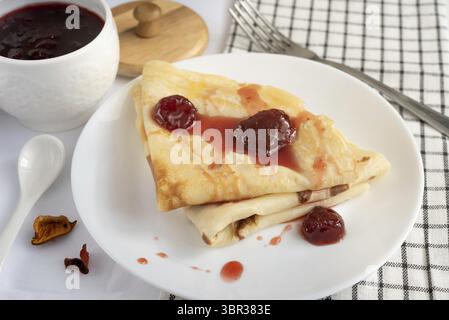 Pfannkuchen mit Erdbeermarmelade auf einem weißen Teller Stockfoto