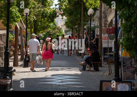 Agios Nikolaos, Kreta, Griechenland - 26. Juni 2025: Besucher schlendern durch eine belebte Straße in Agios Nikolaos und genießen Geschäfte und lokale Atmosphäre. Stockfoto