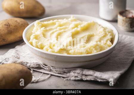 Kartoffelpüree in weißer Schüssel auf grauem Betongrund. Gesunde Ernährung Stockfoto