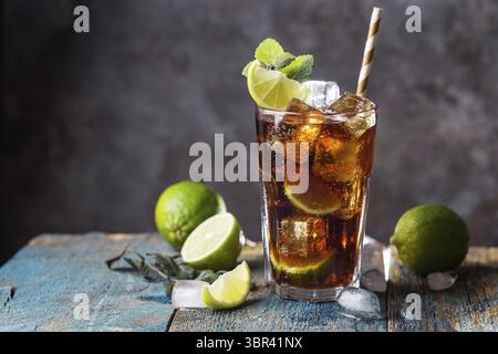 Frisch gemacht Cuba Libre mit brauner Rum, Cola, Minze und Zitrone auf hölzernen Hintergrund Stockfoto