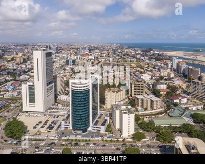 Aus der Vogelperspektive sehen Sie glitzernde Wolkenkratzer und belebte Straßen und treffen auf das azurblaue Wasser der Lagos Lagoon, einem lebendigen städtischen Wandteppich, Lagos, Nigeria. Stockfoto