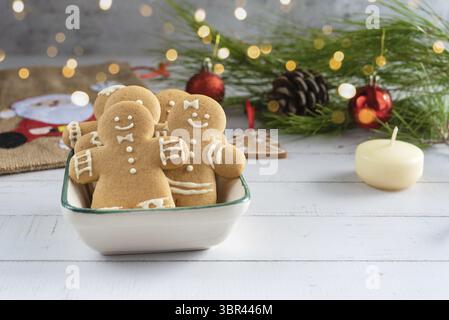 Wunderschöne Weihnachtskarte mit Keksen Lebkuchenmann, Weihnachtsdekoration auf hölzernem Hintergrund Stockfoto