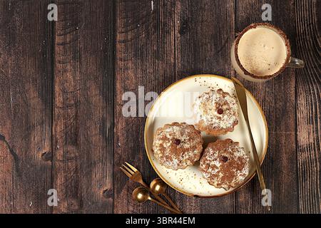 Schokoladen-Muffins mit Muskatnuss und Zimt-Eierlikör auf hölzernem Hintergrund, gemütliches Frühstückskonzept, Werbung für ein Café oder eine Bäckerei. Erwärmendes Eiergetränk Stockfoto
