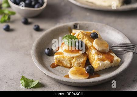 Hausgemachter Quark Bake Cake Auflauf mit Beeren und Banane auf grauem Hintergrund Stockfoto