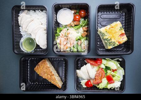 Gesunde Lebensmittelversorgung. Nehmen Sie Nahrung für die Diät. Fitness-Ernährung, ausgewogene Proteine, Fette und Kohlenhydrate in Kunststoffboxen. Draufsicht, flach Stockfoto