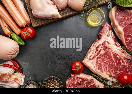Auswahl an frischem Rohfleisch und Würstchen auf schwarzem Hintergrund. Draufsicht mit Platz für Ihren Text Stockfoto