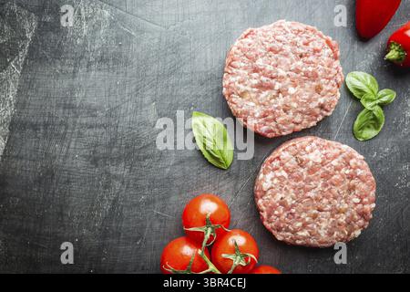 Frisches rohes Prime Black Angus Beef Burger Patties auf schwarzem Hintergrund. Draufsicht Stockfoto