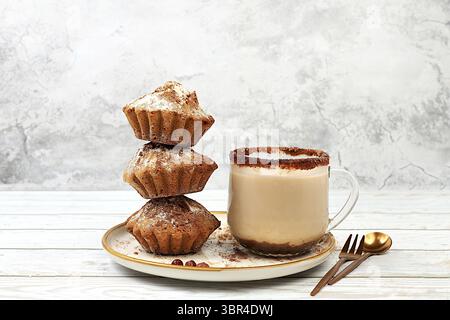 Schokoladen-Muffins mit Muskatnuss und Zimt-Eierlikör auf Betonhintergrund, gemütliches Frühstückskonzept, Werbung für ein Café oder eine Bäckerei. Wärmendes Ei drin Stockfoto