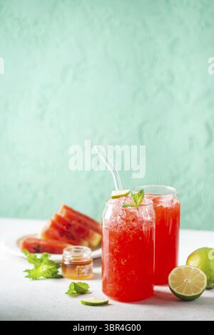 Erfrischender kalter Sommer Wassermelone Drink in Gläsern mit Scheiben von Wassermelone und Limette Stockfoto