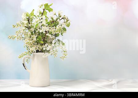 Schöne Frühlingsblühende Apfel- und Vogelkirschzweige in einer Vase auf einem eleganten Hintergrund, Banner. Abstrakte Blumenarrangements, Stillleben mit Spac Stockfoto