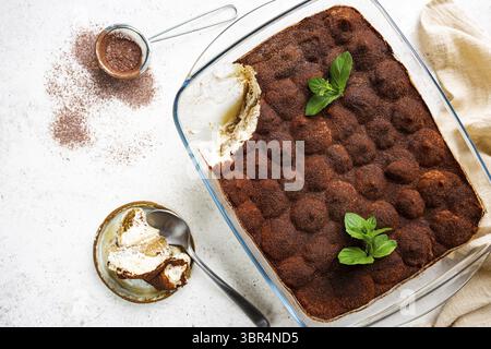 Traditional Italian dessert tiramisu in a glass backing form on light background, top view Stockfoto
