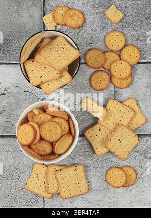Trockener französischer Cracker mit Sesamsamen auf Betonhintergrund. Hausgemachte glutenfreie Schokoladenchips und Nusskekse, modernes Bäckereikonzept. Gesundes Frühstück Stockfoto