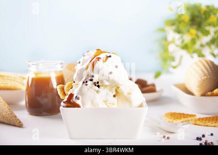 Frisches Süßeis mit Karamellsauce, Waffeln, Kegeln. Sommer-Food-Konzept Stockfoto