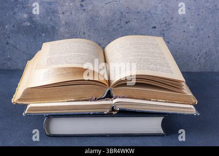 Stapel offener Bücher auf blauem abstraktem Hintergrund, Kopierraum Stockfoto