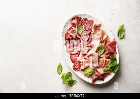 Vorspeisen mit verschiedenen Antipasti, Wurstwaren, Snacks und Rotwein auf weißem Hintergrund. Wurst, Schinken, Tapas, Oliven und Cracker für eine Buffetparty. Stockfoto