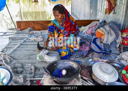 15. Juli 2020, Bogura, Bangladesch: Eine Frau sitzt in ihrem überfluteten Haus in Sariakandi in Bogura. Mehr als vier Millionen Menschen sind von den Monsunfluten in Bangladesch betroffen, wobei ein Drittel des Landes bereits unter Wasser ist, nachdem einige der schwersten Regenfälle seit einem Jahrzehnt stattgefunden haben, sagten Beamte. (Credit Image: © Zabed Hasnain Chowdhury/SOPA Images via ZUMA Wire) Stockfoto