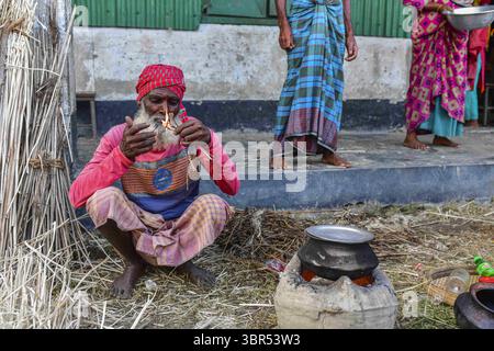 15. Juli 2020, Bogura, Bangladesch: Ein Mann wird in einem provisorischen Unterschlupf beim Kochen gesehen. Mehr als vier Millionen Menschen sind von den Monsunfluten in Bangladesch betroffen, wobei ein Drittel des Landes bereits unter Wasser ist, nachdem einige der schwersten Regenfälle seit einem Jahrzehnt stattgefunden haben, sagten Beamte. (Credit Image: © Zabed Hasnain Chowdhury/SOPA Images via ZUMA Wire) Stockfoto