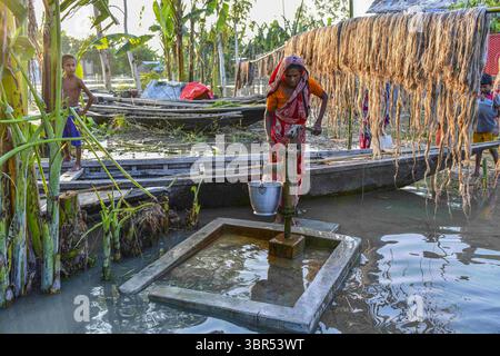 15. Juli 2020, Bogura, Bangladesch: Eine Frau sammelt Trinkwasser aus einer Pumpe in Sariakandi in Bogura. Mehr als vier Millionen Menschen sind von den Monsunfluten in Bangladesch betroffen, wobei ein Drittel des Landes bereits unter Wasser ist, nachdem einige der schwersten Regenfälle seit einem Jahrzehnt stattgefunden haben, sagten Beamte. (Credit Image: © Zabed Hasnain Chowdhury/SOPA Images via ZUMA Wire) Stockfoto