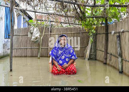 16. Juli 2020, Bogura, Bangladesch: Eine Frau sitzt vor ihrem überfluteten Haus in Bogura. Ein Drittel von Bangladesch ist unter Wasser, nachdem heftige Regenfälle das Land getroffen haben. Mindestens 1,5 Millionen Menschen sind betroffen, Häuser und Straßen in Dörfern sind überflutet. Beamte des Flood Forecasting and Warning Centre (FFWC) berichteten, dass die Hochwassersituation in 15 nördlichen und zentralen Distrikten auf den Anstieg der Wasserstände der wichtigsten Flüsse, einschließlich Brahmaputra, Jamuna, Padma, Teesta und Dharla, zurückzuführen ist. (Credit Image: © Zabed Hasnain Chowdhury/SOPA Images via ZUMA Wire) Stockfoto