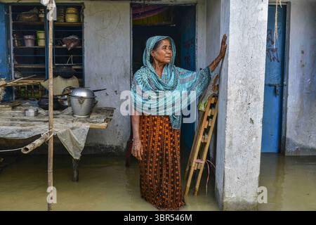 16. Juli 2020, Bogura, Bangladesch: Eine Frau steht vor ihrem überfluteten Haus in Bogura. Ein Drittel von Bangladesch ist unter Wasser, nachdem heftige Regenfälle das Land getroffen haben. Mindestens 1,5 Millionen Menschen sind betroffen, Häuser und Straßen in Dörfern sind überflutet. Beamte des Flood Forecasting and Warning Centre (FFWC) berichteten, dass die Hochwassersituation in 15 nördlichen und zentralen Distrikten auf den Anstieg der Wasserstände der wichtigsten Flüsse, einschließlich Brahmaputra, Jamuna, Padma, Teesta und Dharla, zurückzuführen ist. (Credit Image: © Zabed Hasnain Chowdhury/SOPA Images via ZUMA Wire) Stockfoto