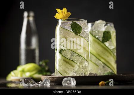 Gurke in ein Glas mit Eis eingegossen Detox-Wasser mit Minze. Hausgemachte Limonade mit Geschmack auf dunklem Hintergrund Stockfoto