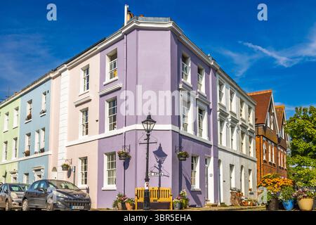 Lebhafte Pastellterrassenhäuser in einer sonnigen Eckstraße. Folkestone, Großbritannien, 11. Mai 2024 Stockfoto