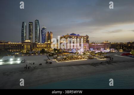 Dubai, Vereinigte Arabische Emirate - 16. Juni 2025: Aus der Vogelperspektive auf das Emirates Palace Hotel und die Skyline der Stadt, die vor dem Abendhimmel schimmert, eine Mischung aus moderner Architektur und arabischem Luxus. Stockfoto