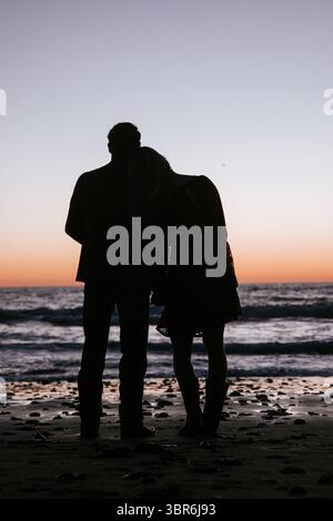 Frau, die während des Sonnenuntergangs Kopf auf dem Freund ausruht Stockfoto