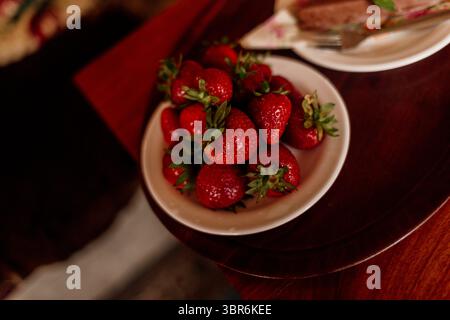 Erdbeeren und Schokoladenkuchen auf einem hölzernen Café-Tisch Stockfoto