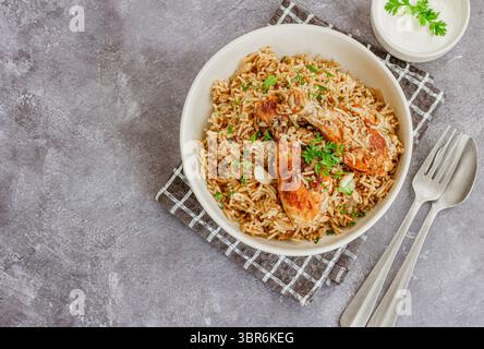 Huhn und Reis auf einem Teller mit Joghurt Stockfoto