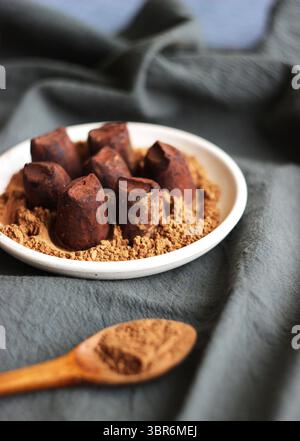 Trüffelbonbons liegen auf einem Teller auf einem Handtuch auf dem Tisch Stockfoto