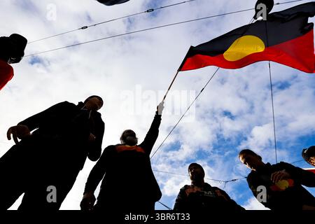 Ein Teilnehmer winkt während des VIC NAIDOC-Marsches eine Aborigine-Flagge. Der NAIDOC March (National Aborigines and Islanders Day Observance Committee) von 2025 versammelte Gemeinschaften und Verbündete der ersten Nationen, um die Kultur der Aborigines und der Torres Strait Islander zu feiern, sich für Gerechtigkeit einzusetzen und den anhaltenden Kampf für indigene Rechte und Souveränität zu ehren. Die jährliche Veranstaltung umfasste Vorträge, Aufführungen und einen märz, in dem das diesjährige Thema Resilienz und Selbstbestimmung hervorgehoben wurde. Die NAIDOC-Woche hat ihre Wurzeln im Tag der Trauer 1938, einer der ersten großen Bürgerrechtsversammlungen le Stockfoto
