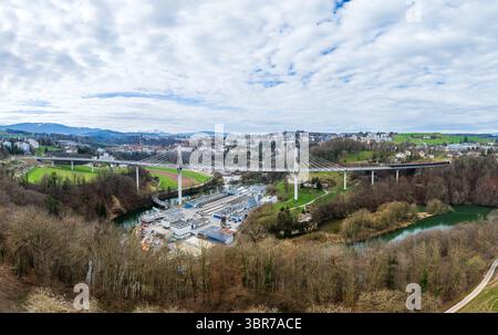 Aus der Vogelperspektive auf die hoch aufragende Brücke Pont de la Poya, die elegant die üppige, grüne Landschaft und den ruhigen Fluss darunter überspannt, Fribourg, Schweiz Stockfoto