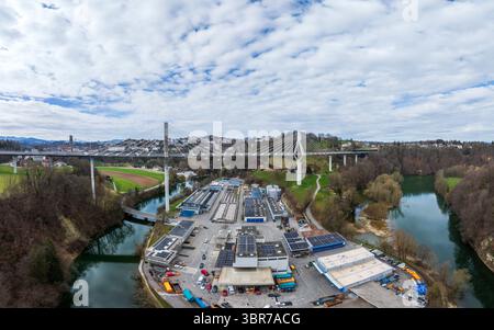 Die elegante, moderne Brücke Pont de la Poya aus der Vogelperspektive erstreckt sich elegant über den sich windenden Fluss, im Kontrast zum üppigen Grün der Umgebung, Fribourg, Schweiz. Stockfoto