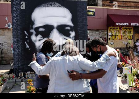 15. August 2020, Minneapolis, Minnesota, USA: Frauen beten vor einem großen Porträt von George Floyd vor Cup Foods am George Floyd Memorial in Minneapolis. Floyd, ein unbewaffneter Schwarzer, wurde am 25. Mai vor Cup Foods, einem Supermarkt an der Kreuzung 38th und Chicago Avenue, von Polizisten aus Minneapolis getötet. Sein Mord löste eine Woche gewalttätiger Proteste im ganzen Land aus. Die Kreuzung, an der er getötet wurde, ist immer noch geschlossen und wurde zu einer inoffiziellen Gedenkstätte, die täglich von Hunderten von Menschen besucht wird. Am Samstag versammelten sich mehr als 100 Menschen in der Gedenkstätte für die dema Stockfoto