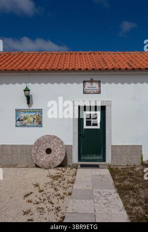 Traditionelles portugiesisches Haus mit rotem Ziegeldach und blauem Zierrand Stockfoto