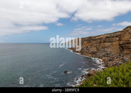 Cliffside Path mit Meerblick und weiß-blauem Zaun in Portugal Stockfoto
