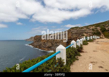 Cliffside Path mit Meerblick und weiß-blauem Zaun in Portugal Stockfoto