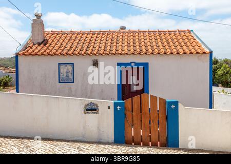 Traditionelles portugiesisches Haus mit rotem Ziegeldach und blauem Zierrand Stockfoto