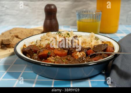 Köstlicher Rindereintopf mit Reis und frischem Brot Stockfoto