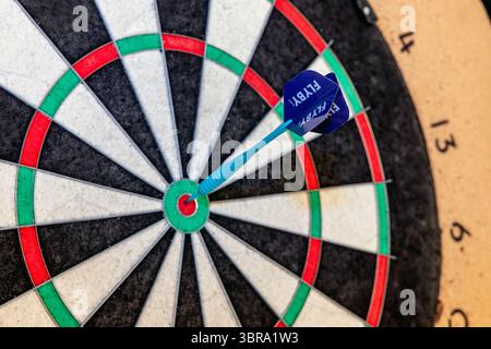 Eine Runde Darts mit einem Pfeil in die Dartscheibe bullseye Stockfoto