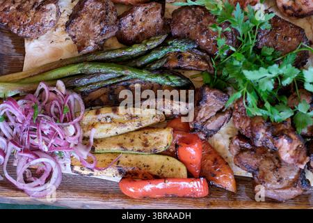 Genießen Sie eine leckere Mischung aus gegrilltem Fleisch und frischem Gemüse, die auf Ihre Gäste warten! Stockfoto