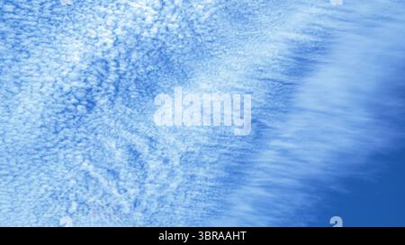 Sanfte Wolken ziehen anmutig über einen hellblauen Himmel und schaffen eine beruhigende Atmosphäre. Stockfoto