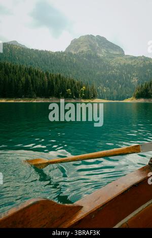 Rudern auf dem klaren Wasser des Schwarzen Sees, umgeben von Kiefernwäldern und Bergen in Montenegro Stockfoto