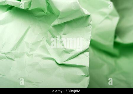Weiches Licht zeigt komplexe Falten und Texturen von grünem Papier. Stockfoto