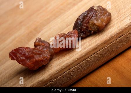 Drei getrocknete Früchte auf einem Holzbrett zeigen lebendige Farben und Texturen. Stockfoto