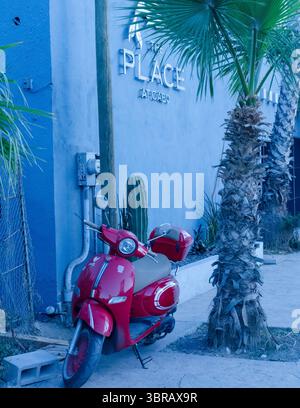 Ein glänzend roter Roller parkt auf dem Bürgersteig in Cabo San Lucas, Mexiko. Stockfoto